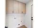 Laundry room offering ample cabinet storage, modern hardware, and space-saving design elements at 5467 W Hinsdale Pl, Littleton, CO 80128