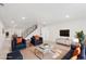Bright living room with comfortable seating, flat-screen TV, and neutral carpet at 5467 W Hinsdale Pl, Littleton, CO 80128