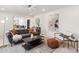 Bright living room featuring modern furniture, a ceiling fan, and an open layout to kitchen area at 5467 W Hinsdale Pl, Littleton, CO 80128