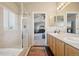 Bathroom with double vanity, shower, and a view into the main bedroom at 5232 Creek Way, Parker, CO 80134