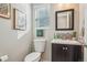 Well-lit half bathroom with modern fixtures, a decorative mirror, and charming wall art at 5232 Creek Way, Parker, CO 80134