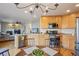 Eat-in kitchen with wood floors and wood cabinetry, offering an open view to the living room fireplace at 5232 Creek Way, Parker, CO 80134