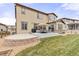 Landscaped backyard with a stone patio, lawn, and seating area at 8035 S Kewaunee St, Aurora, CO 80016