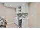 Basement wet bar featuring white cabinets, a wine fridge, and stylish tile backsplash at 8035 S Kewaunee St, Aurora, CO 80016