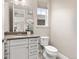 Clean bathroom featuring a white vanity, a framed mirror, and a toilet at 8035 S Kewaunee St, Aurora, CO 80016