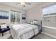 Well-lit bedroom featuring a patterned bedspread, a window seat, and a large window overlooking the outdoors at 8035 S Kewaunee St, Aurora, CO 80016