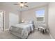 Cozy bedroom featuring a ceiling fan, a soft patterned bedspread, and a comfortable chair near a window at 8035 S Kewaunee St, Aurora, CO 80016