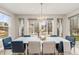 Elegant dining area with bright windows, modern lighting, and a stylish white table set for eight at 8035 S Kewaunee St, Aurora, CO 80016