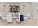 Elegant dining room with a glass-top table, seating for eight, and modern art and light fixtures at 8035 S Kewaunee St, Aurora, CO 80016