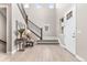 Bright foyer featuring a staircase with iron railings, wood-look floors, and a modern entryway table at 8035 S Kewaunee St, Aurora, CO 80016