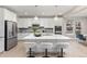 Modern kitchen with stainless steel appliances, a large island with seating, and white cabinetry at 8035 S Kewaunee St, Aurora, CO 80016