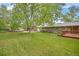 Spacious backyard featuring mature tree, green lawn, and a wooden deck at 8269 Zephyr St, Arvada, CO 80005