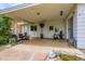 Covered back patio with seating, exercise bike, koi pond, and access to the backyard at 6748 S Gallup St, Littleton, CO 80120