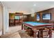 Basement with wood paneled walls, bar, and a pool table for recreation and entertaining at 6748 S Gallup St, Littleton, CO 80120