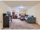 Finished basement with carpet and versatile living space including a bed, couch, and mini-fridge at 6748 S Gallup St, Littleton, CO 80120