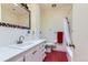 Bathroom with white tile, quirky decorations, and a red tile floor and matching accents at 6748 S Gallup St, Littleton, CO 80120