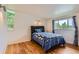 Bright bedroom with hardwood floors, large windows and stylish blue and white patterned bedding at 6748 S Gallup St, Littleton, CO 80120
