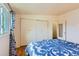 Bedroom with hardwood floors and an expansive closet with a partial view of the bed with blue bedding at 6748 S Gallup St, Littleton, CO 80120