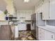 Functional kitchen with white cabinets, stainless steel appliances, and unique flooring, blending style and utility at 6748 S Gallup St, Littleton, CO 80120