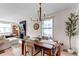 Bright dining room with hardwood floors, modern lighting, and open concept to living room with fireplace at 3052 S Cherokee St, Englewood, CO 80110