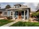 Charming blue home featuring a cozy front porch with seating at 3052 S Cherokee St, Englewood, CO 80110