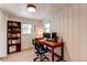 Well-lit home office with a wooden desk and ample storage at 3052 S Cherokee St, Englewood, CO 80110