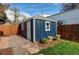 Charming shed featuring a fresh coat of dark blue paint with white trim and a neatly landscaped surrounding at 3052 S Cherokee St, Englewood, CO 80110