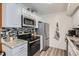 Well-lit kitchen offering stainless steel appliances, granite countertops, and wood-look vinyl flooring at 1074 S Dearborn St # 107, Aurora, CO 80012