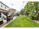 Beautifully landscaped backyard featuring a spacious lawn and covered patio seating area at 11725 Helena St, Commerce City, CO 80022