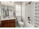 Cozy bathroom featuring a vanity with sink, toilet, and bathtub-shower with a shower curtain at 11725 Helena St, Commerce City, CO 80022