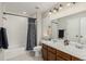 Bright bathroom with double sink vanity, tile flooring, and shower-tub combination with neutral tones at 11725 Helena St, Commerce City, CO 80022