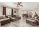 Open-concept living room featuring hardwood floors, a ceiling fan, and a view of the kitchen at 11725 Helena St, Commerce City, CO 80022