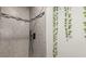 Modern tiled shower with elegant black and gray accent, plus vine decor at 11725 Helena St, Commerce City, CO 80022