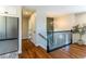 Hallway featuring hardwood floors, a modern refrigerator, and access to the upper level via a staircase at 9410 Perry St, Westminster, CO 80031