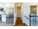 Hallway featuring hardwood floors, stainless steel refrigerator, and staircase with a modern railing at 9410 Perry St, Westminster, CO 80031