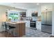 Contemporary kitchen featuring white cabinetry, stainless steel appliances, and a stylish island with bar seating at 9410 Perry St, Westminster, CO 80031