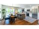 Well-lit kitchen and dining area with hardwood floors, a modern island, and stainless steel appliances at 9410 Perry St, Westminster, CO 80031