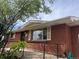 Exterior view of brick home with access ramp and well-manicured landscaping at 7127 Otis St, Arvada, CO 80003