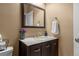 Bathroom featuring a dark vanity with a marble countertop, framed mirror and decorative elements at 2669 Red Bird Trl, Castle Rock, CO 80108