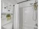 Close up of a well-lit bathroom featuring white tiled shower and bathtub, along with decorative plants and storage at 9110 Gale Blvd # 3, Thornton, CO 80260