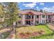 Two story home with a hot tub, patio seating, and lush green backyard with fence at 1007 Nob Hill Rd, Evergreen, CO 80439