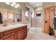 Well-lit bathroom features a glass shower, wood cabinets and trim, tile flooring and neutral color palette at 1007 Nob Hill Rd, Evergreen, CO 80439