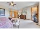 Spacious main bedroom with a ceiling fan, fireplace, walk-out to the porch, and stylish furnishings at 1007 Nob Hill Rd, Evergreen, CO 80439