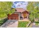 Charming home exterior featuring a stone facade, wood garage door, and inviting front porch at 1007 Nob Hill Rd, Evergreen, CO 80439