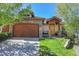 Charming home featuring a stone facade, wood garage door, and inviting front porch at 1007 Nob Hill Rd, Evergreen, CO 80439