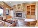 Cozy living room featuring a stone fireplace, built-in shelving, and comfortable seating at 1007 Nob Hill Rd, Evergreen, CO 80439