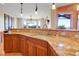 Close up of kitchen with granite counters, tile backsplash, stainless sink, and mountain views at 1007 Nob Hill Rd, Evergreen, CO 80439