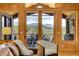 Living area with mountain view through large glass doors leading to an outdoor balcony at 1007 Nob Hill Rd, Evergreen, CO 80439