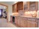 Stylish wet bar features custom cabinetry, granite countertops, wine rack and cooler for entertaining at 1007 Nob Hill Rd, Evergreen, CO 80439