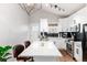 Bright kitchen with white cabinetry, stainless steel appliances, island, and black backsplash at 4800 S Tabor St, Morrison, CO 80465